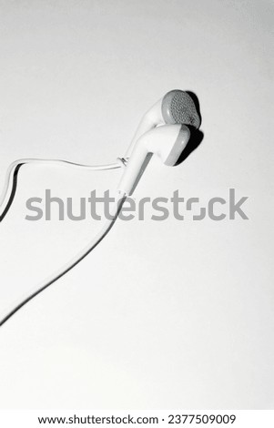 a pair of white old tangled wired earphone on white background concept image