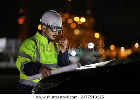 The Specialist electrical engineer communicated with the team via walkie-talkie at night against the  light of bokeh in the background Royalty-Free Stock Photo #2377510225