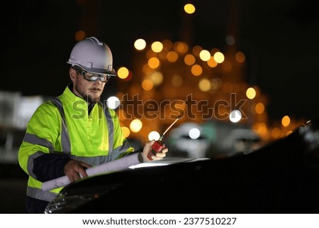 The Specialist electrical engineer communicated with the team via walkie-talkie at night against the  light of bokeh in the background Royalty-Free Stock Photo #2377510227