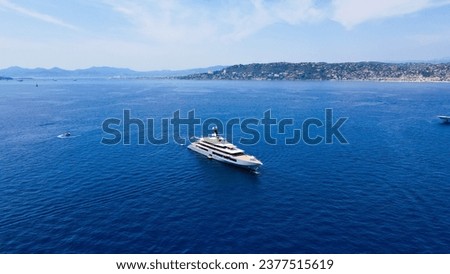Aerial view of luxury yacht cruising in deep blue sea near Mediterranean. Drone tracking photo of modern yacht preparing to speed in Cap d'antibes, côte d'azur, Franch Riviera. Big white modern boat.