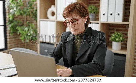 Mature hispanic woman business worker using laptop working at office