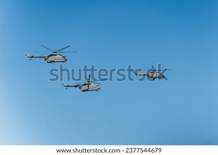 Three helicopters flying on a clear day at a military parade rehearsal. War copter and equipment used in army. Apache military chopper. High quality photo