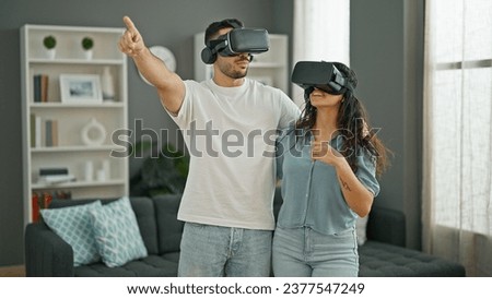 Man and woman couple playing video game using virtual reality glasses at home