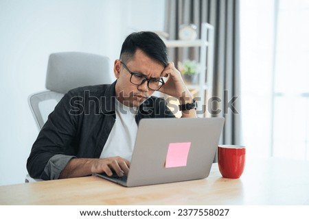 Asian business freelance man wear glasses having stressful depression sad time while working on laptop at home. Depression man sad serios working from home. Working at anywhere concept.
