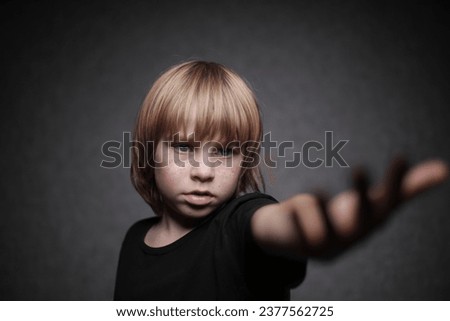 boy in a black T-shirt with his hand outstretched forward in the shadow side of life