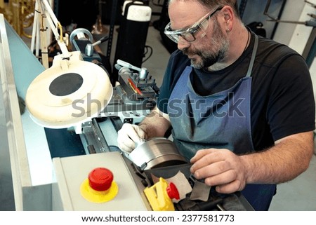musical instrument repairer using a lathe in a luthier shop