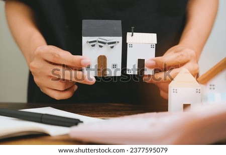 Woman hand hold small house or real estate business concept.