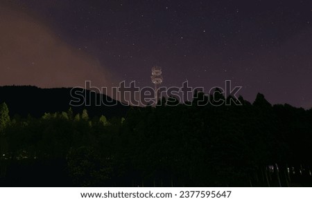 Steel tower, starry sky and mountains