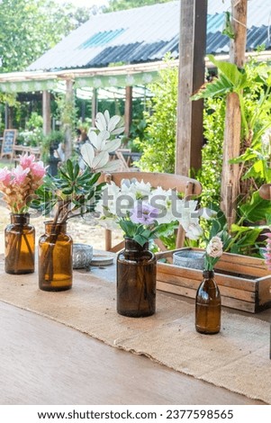 Beautiful flowers and Blue Hydrangea flowers in vase on wooden table at outdoor restaurant.