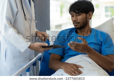 Young man with fever lying in bed with her shaking in hospital background Sick male patient lying in bed with doctor taking care of him, health insurance concept.