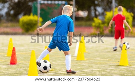 Children in Blue and Red Soccer Team in Training. Two Kids Playing Football Ball on Grass Field. Happy School Boys Kicking Ball During Practice Game