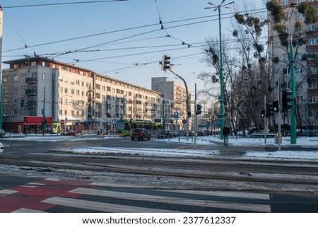 Street with snow, vehicles and tram