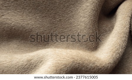 Beige coat fabric, alpaca. Texture of warm wool fabric. Winter clothes. Natural wool, beige wool pile fabric. Royalty-Free Stock Photo #2377615005
