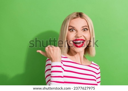 Photo of impressed woman with bob hairdo dressed striped shirt look directing at empty space discount isolated on green color background