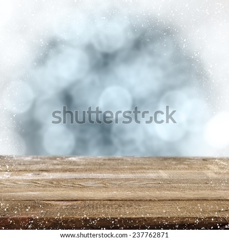 christmas background of blue color and snowflakes and brown desk of wood 