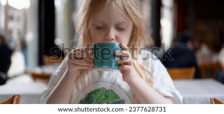 Young girls enjoy hot beverage in a cafe. 