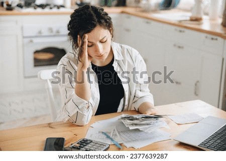Stressed caucasian woman trying to deal with financial documents, having problem to find money to pay utility bills or loans. The concept of debt, bankrupt. Accounting companies advertisement mockup Royalty-Free Stock Photo #2377639287