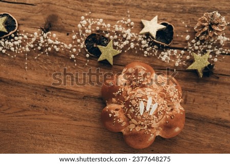 King Cake, also known as Dreikönigskuchen in Switzerland, baked on January 6 with a hidden fève inside as a tiny king figurine. Festive wooden background.