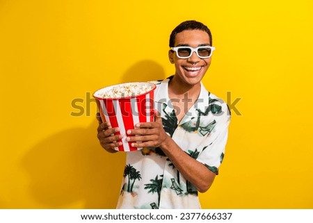 Photo of cheerful cool guy wear stylish outfit hand hold tasty popcorn enjoy comedy film isolated on vibrant yellow color background