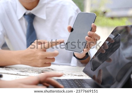 Business man and woman working and looking at a mobile phone in the office..