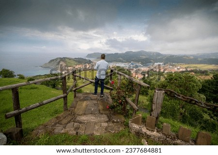Storm clouds over Zumaia in the coast of Gipuzkoa Basque country Spain man at lookout  Royalty-Free Stock Photo #2377684881