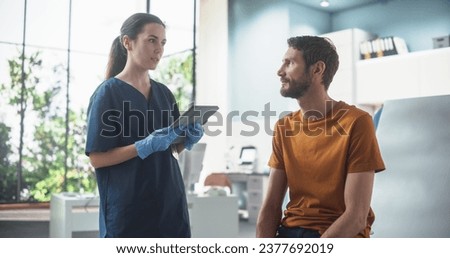Caucasian Man Sitting In The Chair In Bright Hospital And Listening To Female Nurse With Tablet Computer. Professional Woman Explaining Possible Side Effects After Vaccination Or Medicine Injection.