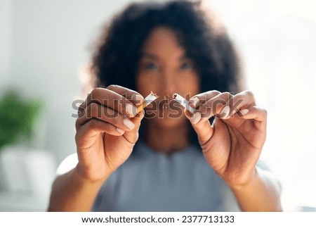 Close-up of woman breaking down cigarette to pieces. Quit smoking concept Royalty-Free Stock Photo #2377713133