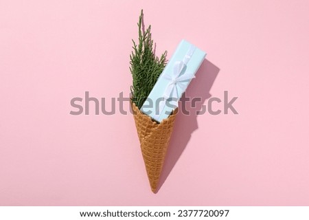 Waffle cone with a gift and a sprig of needles