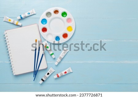 Painting tools on color wooden background, top, view