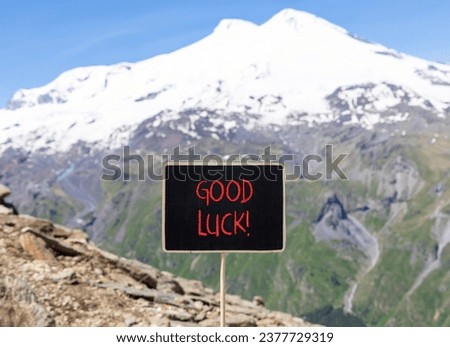 Good luck symbol. Concept words Good luck on beautiful black chalk blackboard. Beautiful mountain Elbrus blue sky background. Business, motivational good luck concept. Copy space.