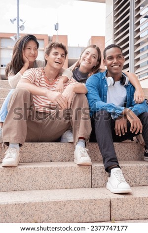 Vertical shot Happy multiethnic group of young friends bonding outdoors.