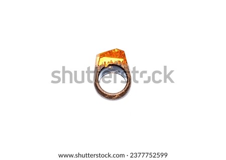 Photo of a wooden ring with epoxy resin on a white background. A women's accessory made from environmentally friendly materials for any event.