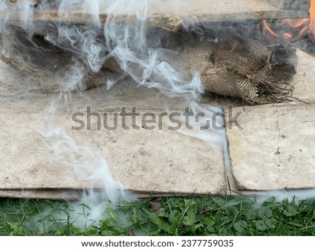 Burning of old scraps from house cleaning in Velmovice village in the Czech Republic with smoke and flames. Toxic gas emissions in smoke damage environment and poison soil. It is forbidden but usual.