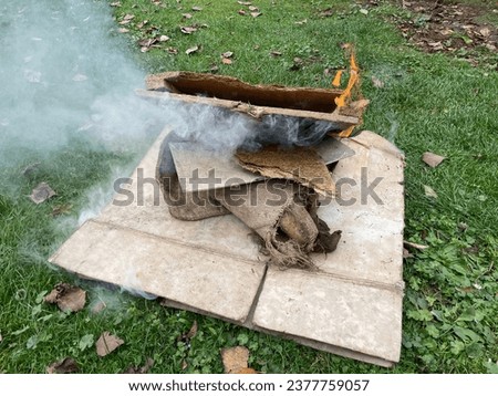 Burning of old scraps from house cleaning in Velmovice village in the Czech Republic with smoke and flames. Waste incineration causes toxic smog and emissiones of co2 with consequent greenhouse effect