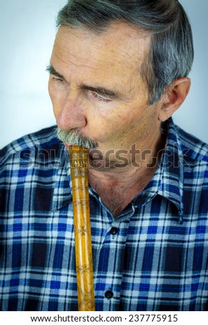 Man playing on pipe flute.Traditional folk instruments of Balcan