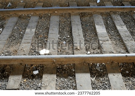 Unused railroad tracks still with gravel and a lot of dirt. zoom photo