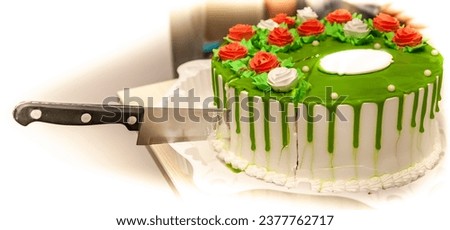 Anniversary cake decorated with white and red roses made of cream with a piece cut with a kitchen knife close-up on a white background