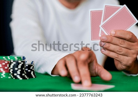 Man playing cards in casino, closeup Royalty-Free Stock Photo #2377763243
