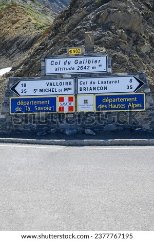 Road sign on mountain pass Col du Calibier, border of Savoy and Hautes Alpes, Massif des Ecrins, Hautes Alpes, France in summer