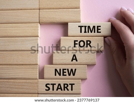 Time for a new start symbol. Wooden blocks with words Time for a new start. Beautiful pink background. Businessman hand. Business and Time for a new start concept. Copy space.
