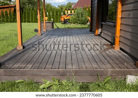 Old weathered wooden deck and new facade of a modern house Royalty-Free Stock Photo #2377770605