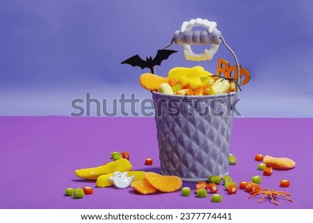 Traditional festive composition for Halloween party. Sweet seasonal food, homemade autumn decor. Hard light, dark shadow, purple background, flat lay, copy space