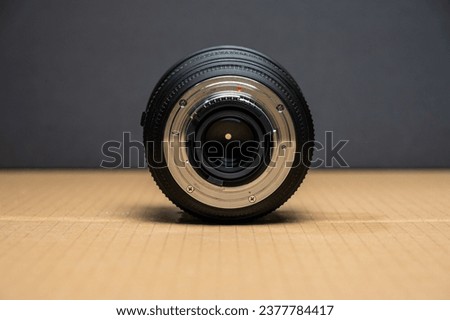 Rear of a photographic lens on a brown table.