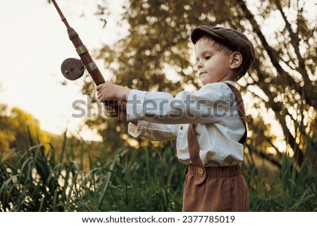 Kid with fishing-rod. Child fishing at autumn lake