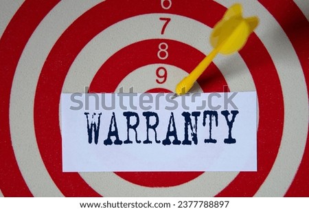 WARRANTY - word on a white piece of paper on the background of a target for dards. Business concept