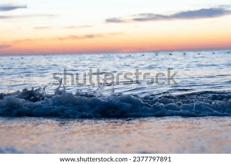 Ocean waves crash at a Pacific Ocean sunset