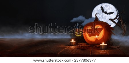 Halloween pumpkins festive background. Moonlight and candlelight. Jack-o-lantern halloween mystic background with mist, spiders, bat and fog, bats.