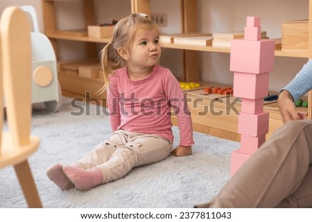 Young little girl sitting on the floor in the kindergarten
