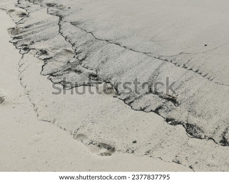 Dark tide mark on dull sandy beach with space for copy