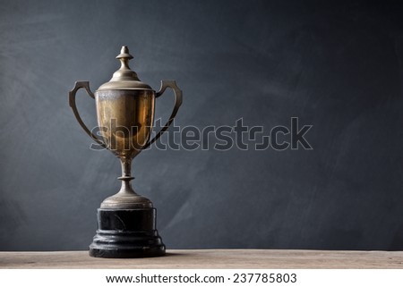 still life photography :  old trophy on old wood with space of art dark background